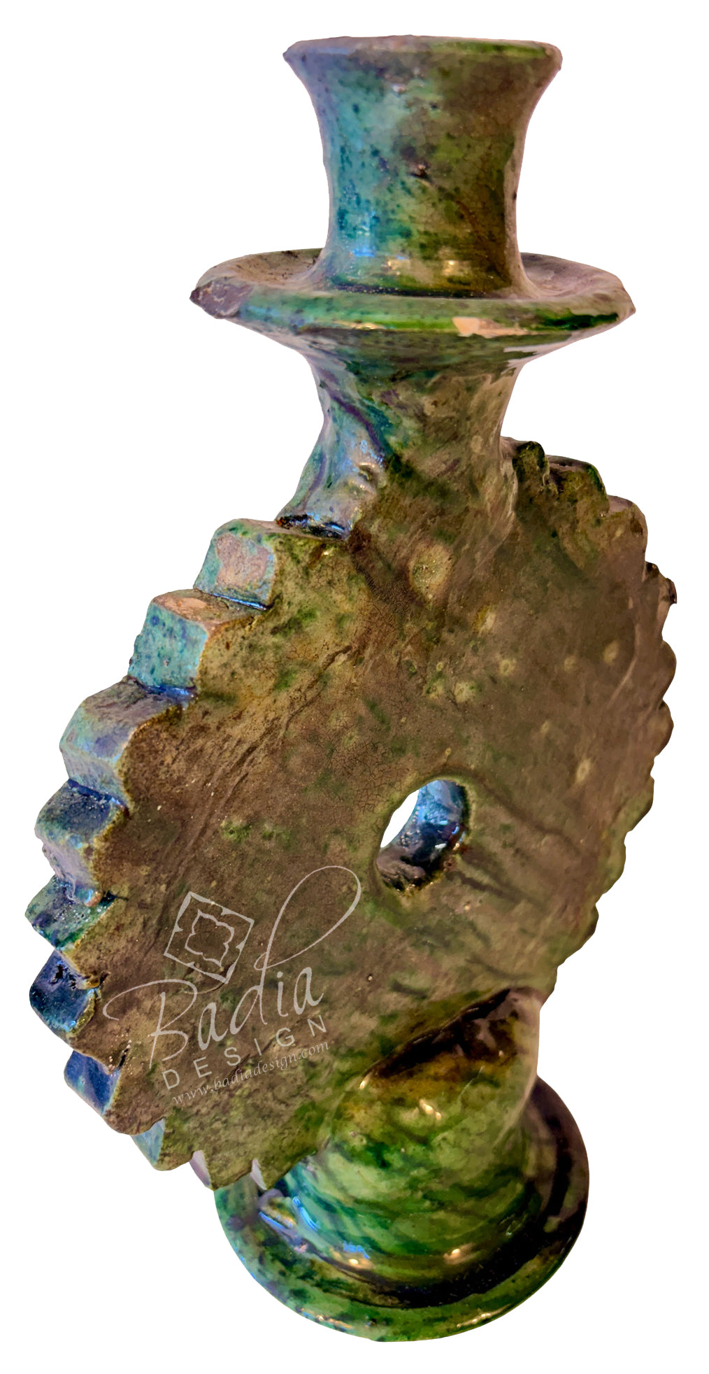 An organic-shaped ceramic candle holder with a textured, sculptural design featuring a central hole and a flared top, decorated with a green and blue glazed finish on a white background.