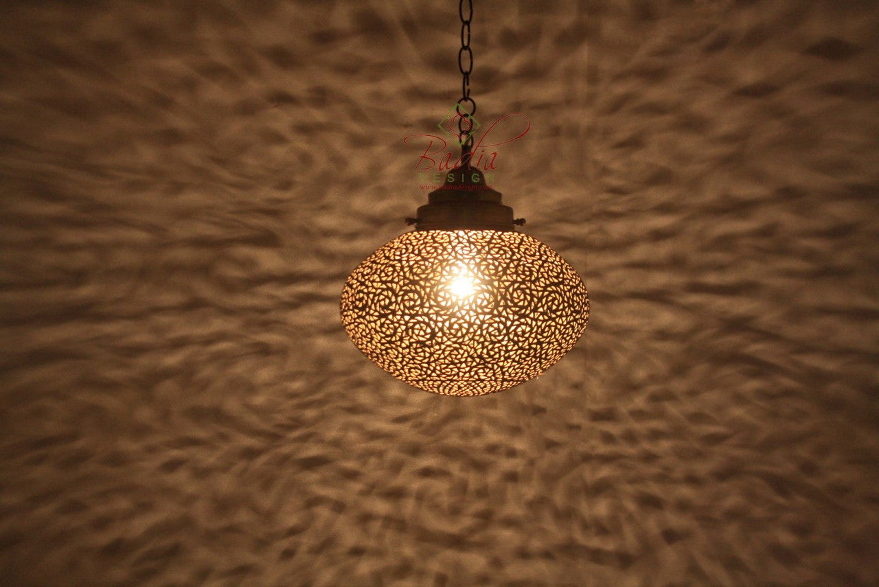 Decorative pendant light with intricate design on a textured wall.