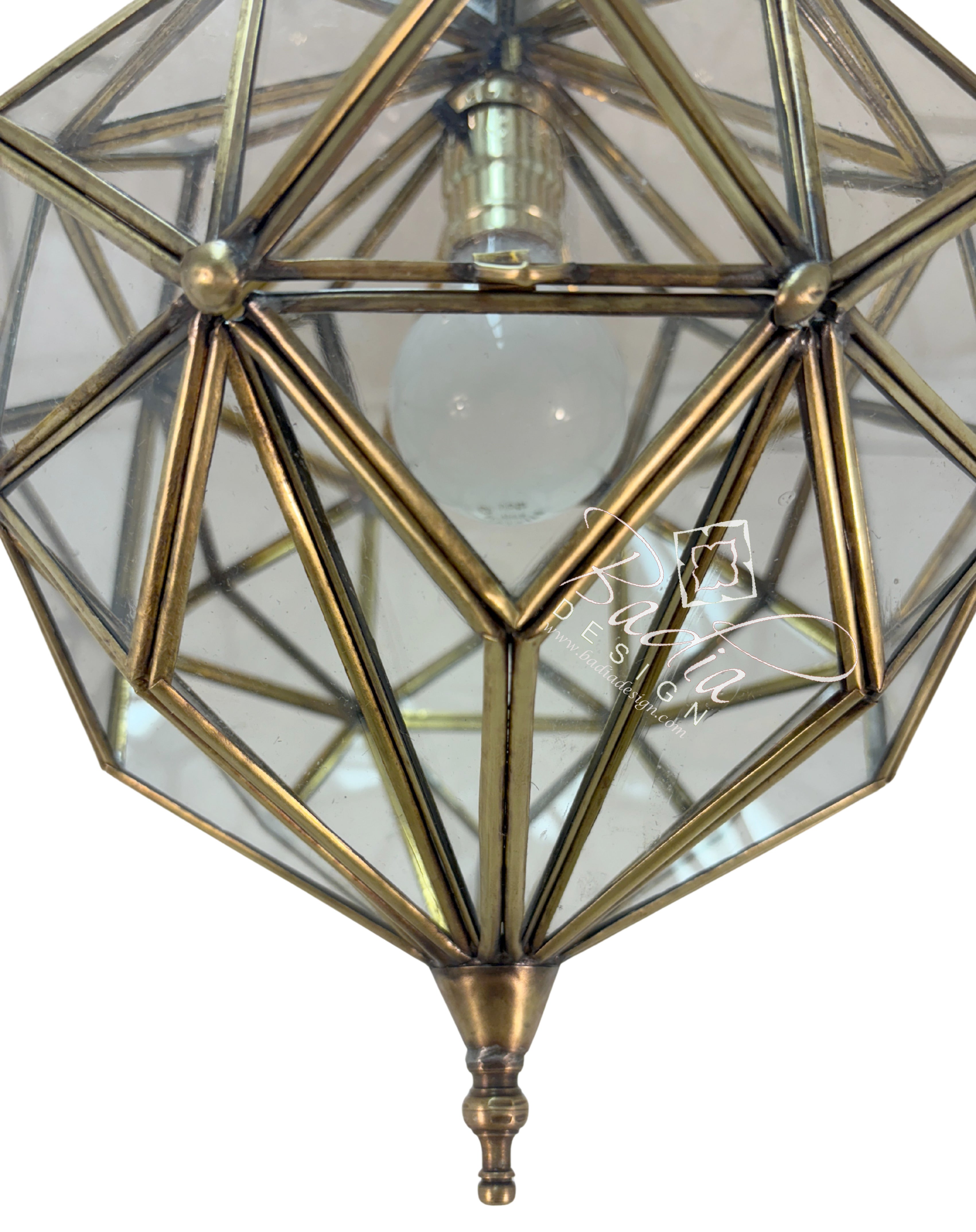 Geometric brass pendant light with clear glass cover on a white background