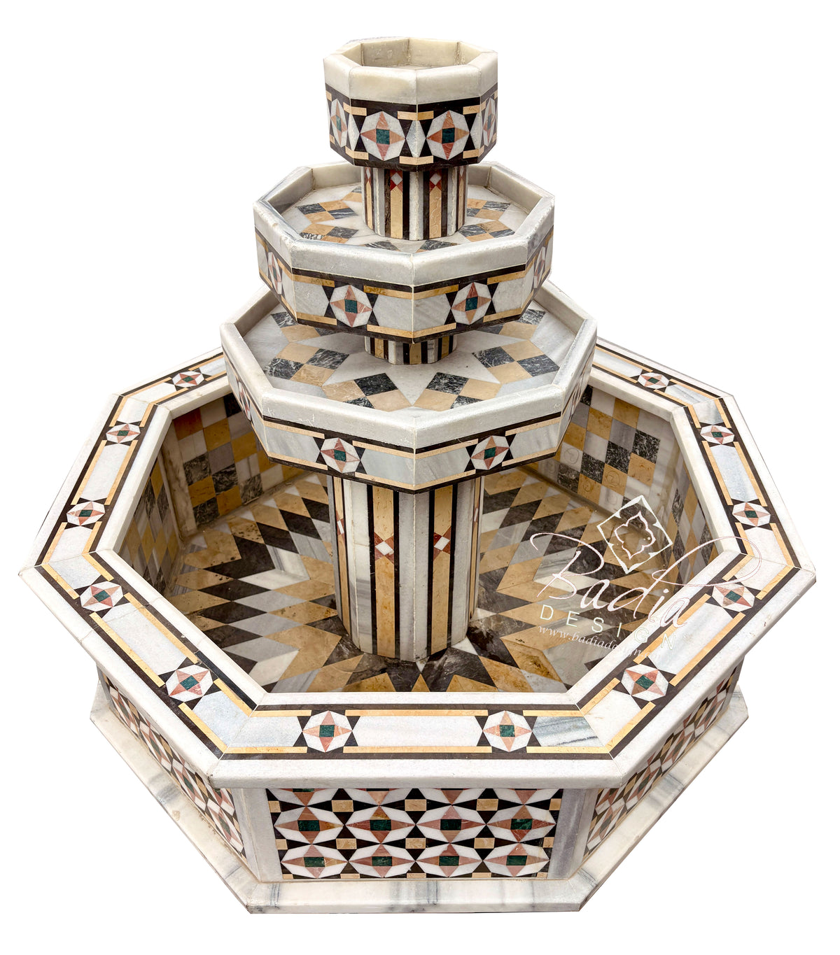 An ornate octagonal stone fountain with tiered levels and intricate geometric mosaic inlay in beige, brown, black, and white, shown on a plain white background.