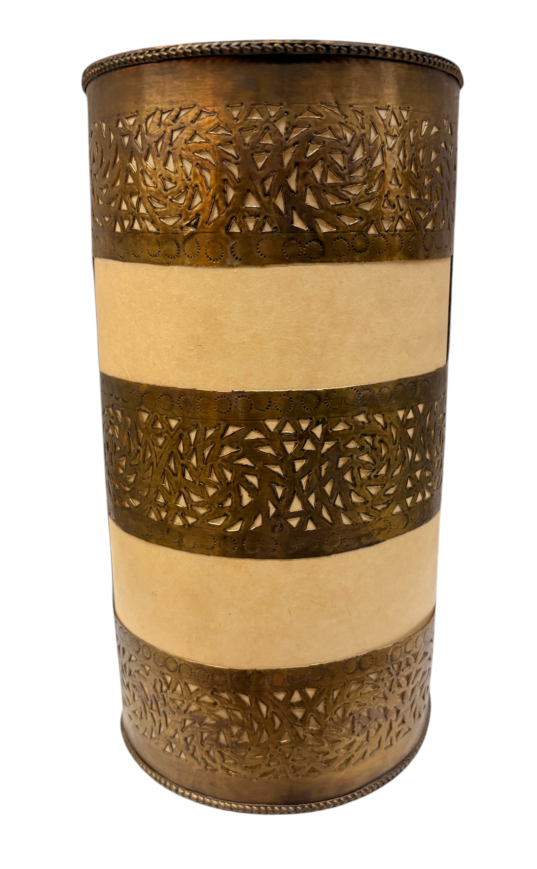 A cylindrical decorative object with a brass-toned metal body featuring intricate laser-cut geometric and floral patterns, separated by three horizontal bands of beige fabric.