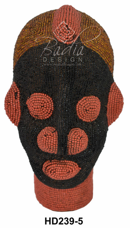 Beaded African head with intricate patterns on a white background