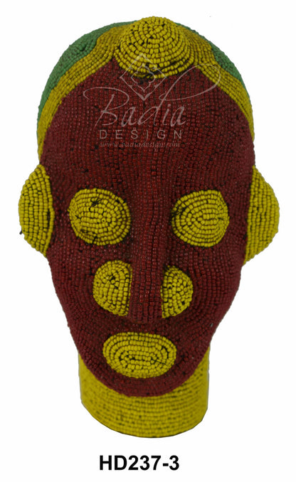 Decorative beaded head with beadwork in red, green, and yellow on a white background