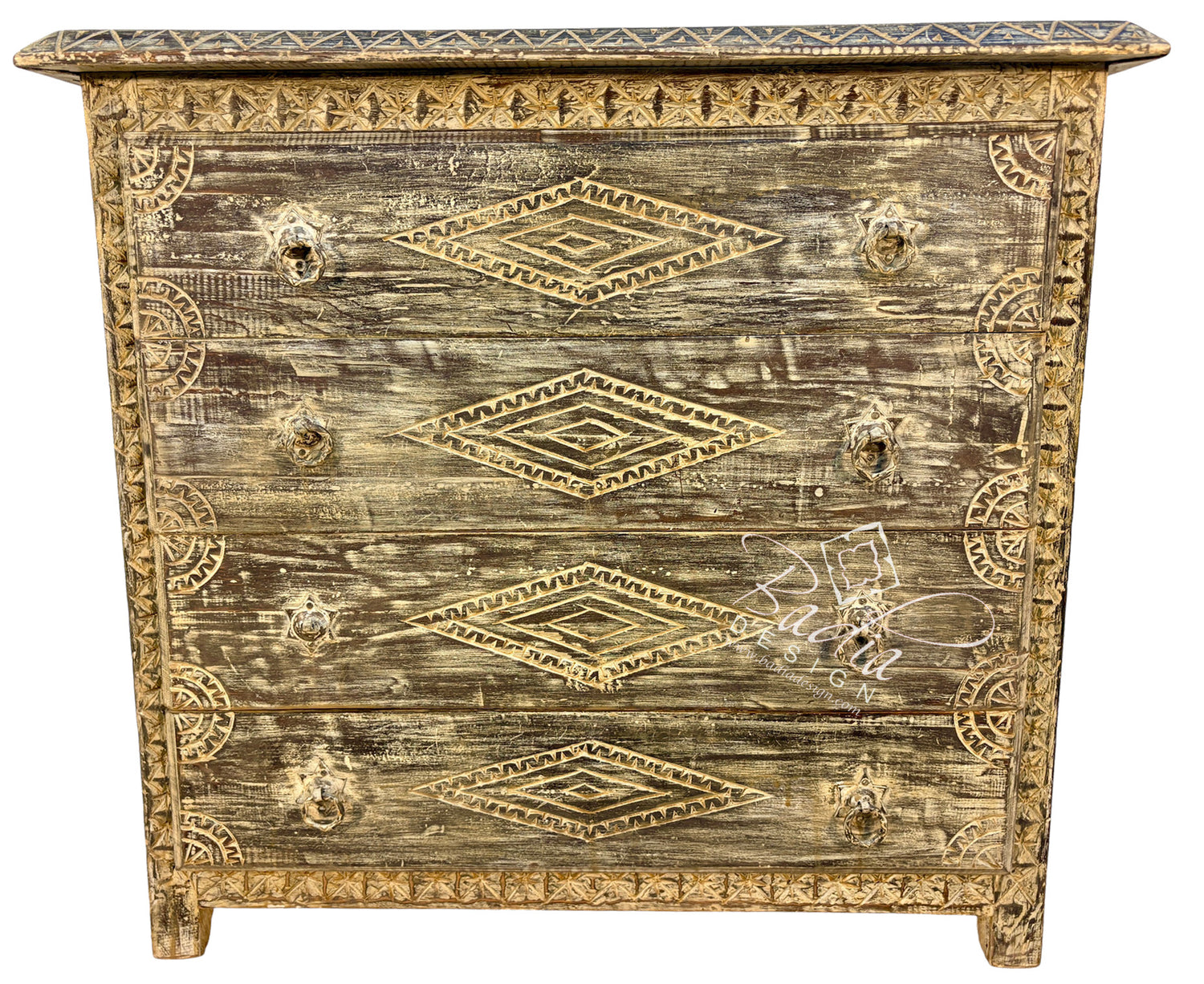A distressed wooden chest of drawers with a weathered brown and beige finish, decorated with gold-toned geometric patterns and ornate drawer pulls.