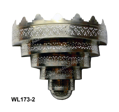 Decorative silver metal wall light fixture with intricate patterns on a white background