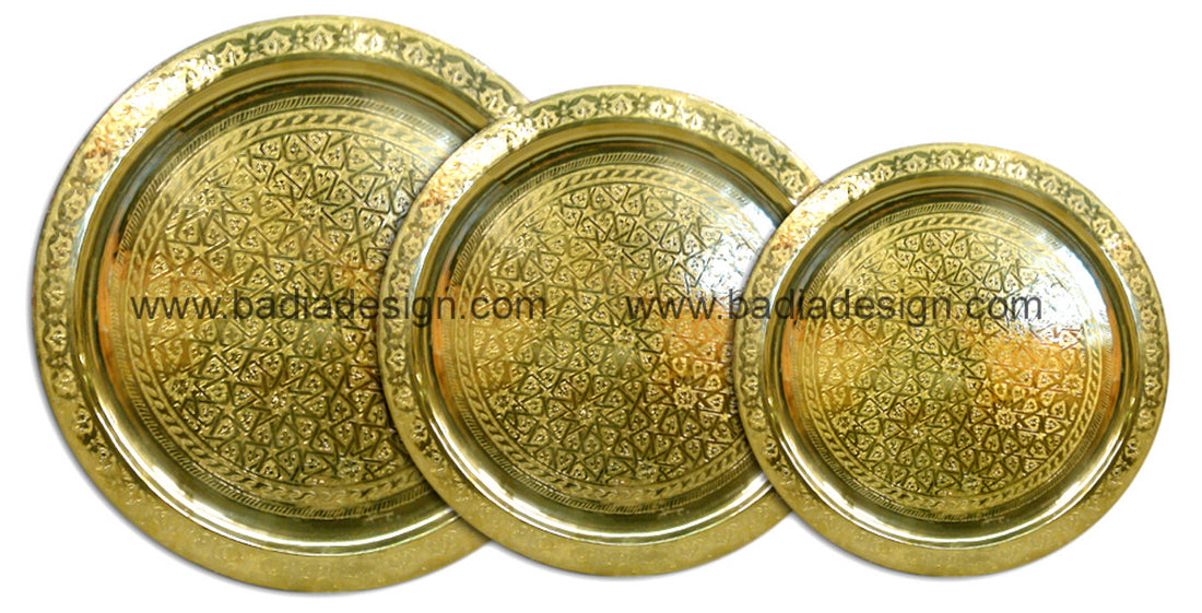 Three gold decorative trays with intricate patterns on a white background