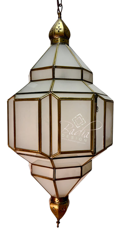 A hanging lantern-style pendant light with geometric glass panels and brass-toned metal framing, shown against a plain white background. A faint &