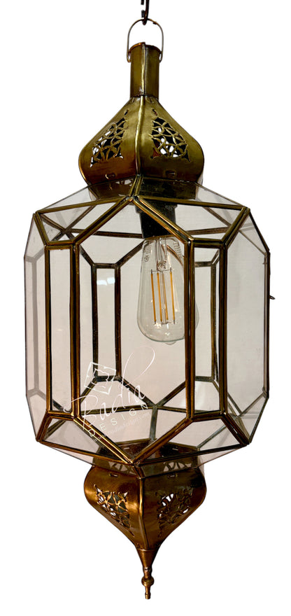 An ornate brass hanging lantern with clear glass panels and a visible filament light bulb, isolated on a white background.