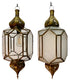 Two ornate hanging lanterns with brass-toned metal frames and clear glass panels, shown side by side against a white background. One lantern is open, revealing an exposed bulb, and the other is closed with a frosted or opaque inner panel.