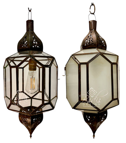 Two traditional Moroccan-style hanging lanterns with dark bronze metal frames and clear glass panels, shown against a plain white background. One lantern is open, displaying an Edison bulb, and the other shows the back with a &