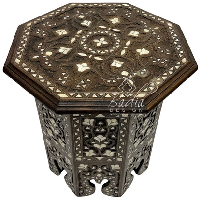 Decorative octagonal table with intricate patterns on a white background, featuring the Badia Design logo.