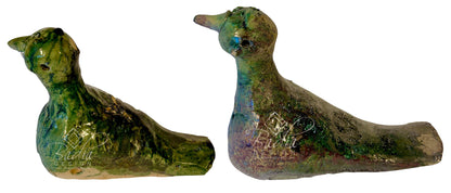 Two small ceramic duck figurines with a textured, glossy finish in green, blue, and brown glazes, shown side by side against a plain white background.