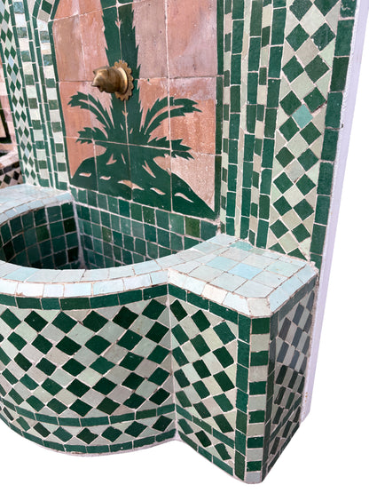 Mosaic tiled fountain with geometric patterns and a palm tree design.