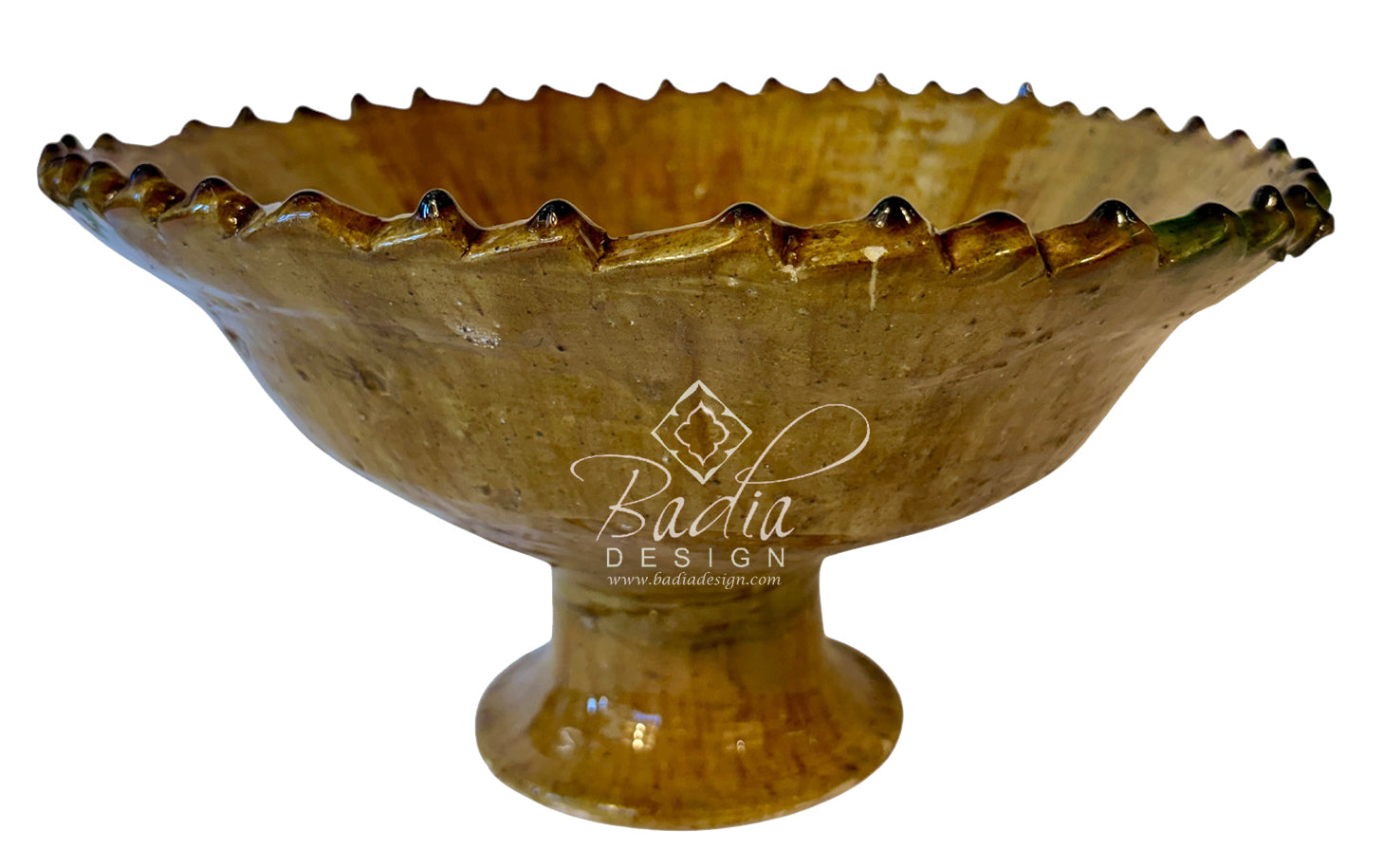 A golden-brown ceramic pedestal bowl with a scalloped rim, shown against a plain white background with a &