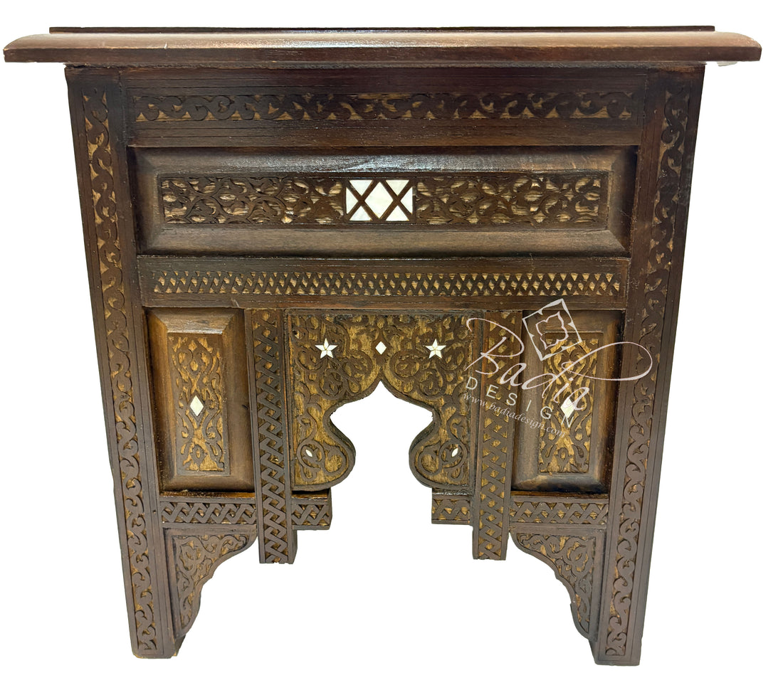 Decorative square wooden side table with intricate carvings on a white background