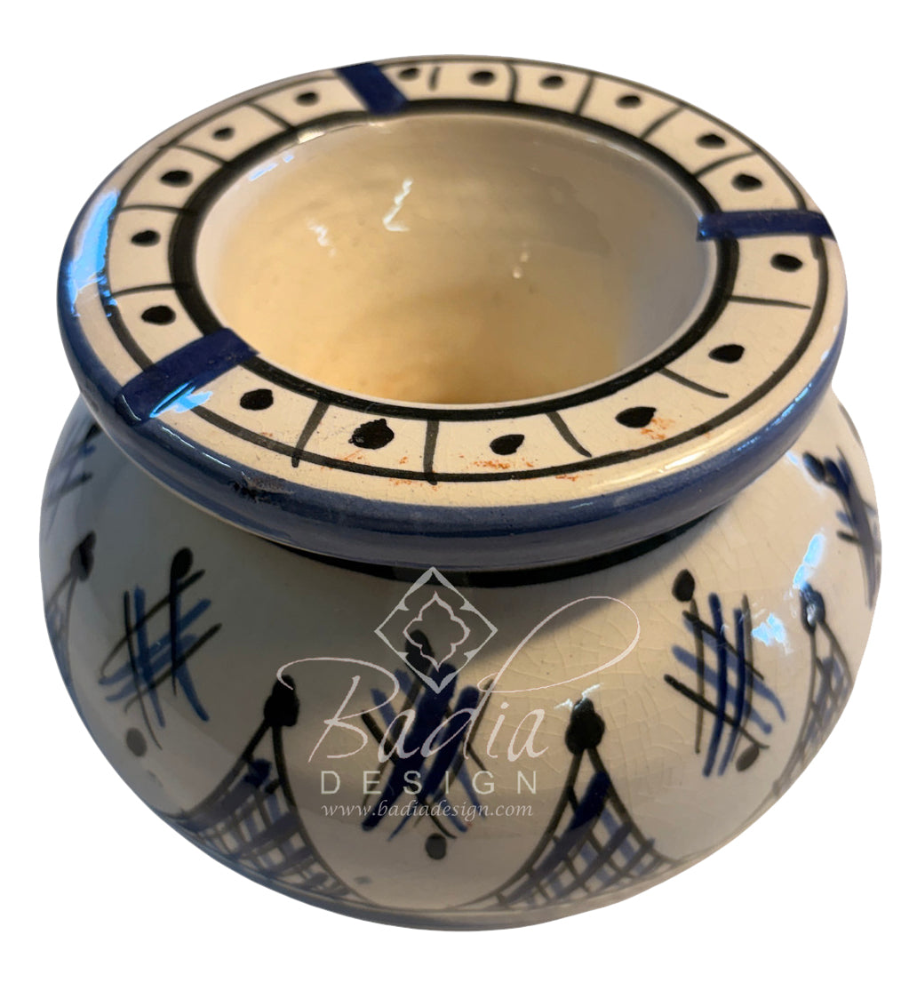 A small ceramic planter pot with a wide rim, decorated with blue geometric patterns and abstract brushstrokes on a cream-colored glaze. The pot features a prominent watermark for &