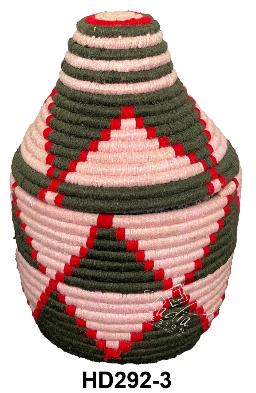 Decorative woven basket with pink and green pattern on a white background