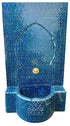 A blue mosaic fountain wall and basin with an arched niche, tiled in shades of blue with a small gold spout, shown on a white background.