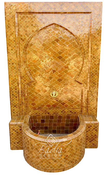 A Moorish-style mosaic fountain wall with a curved basin and arched niche, covered in shimmering gold and amber tiles, shown on a plain white background.