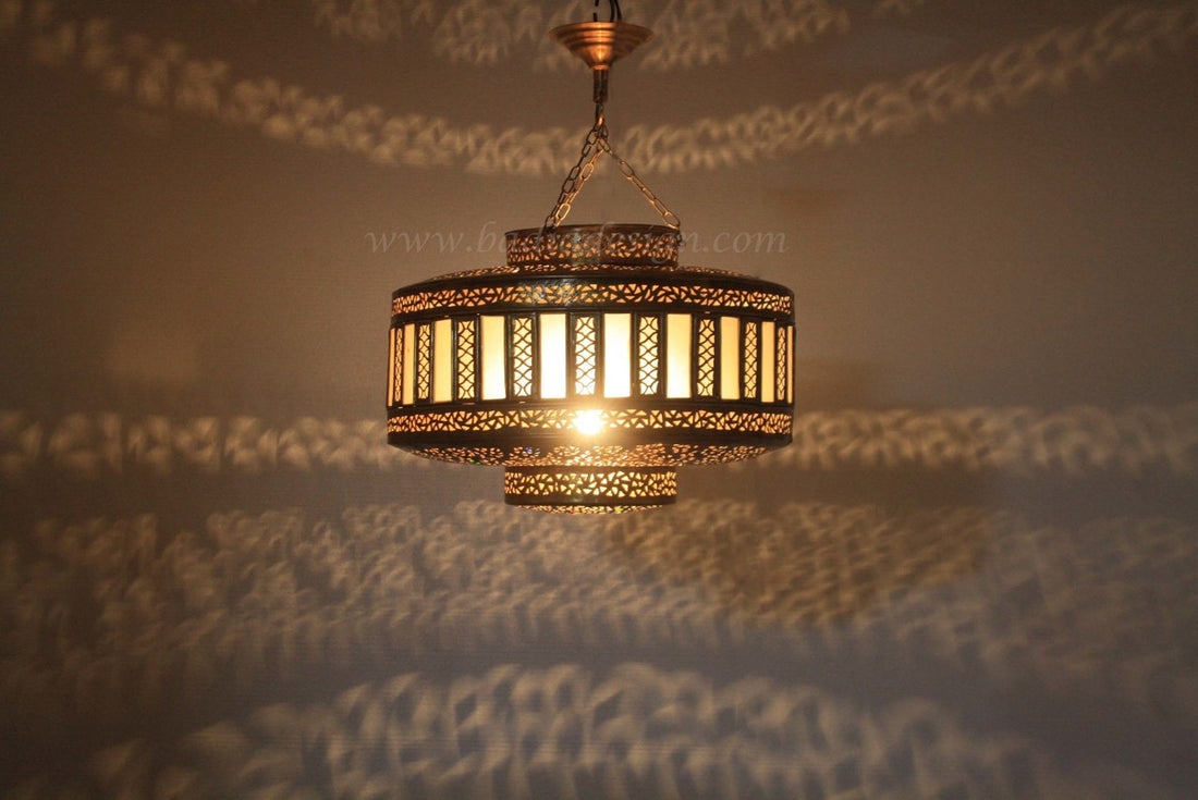Decorative hanging light fixture with intricate design on a textured surface.