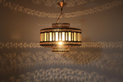 Decorative hanging light fixture with intricate design on a textured surface.