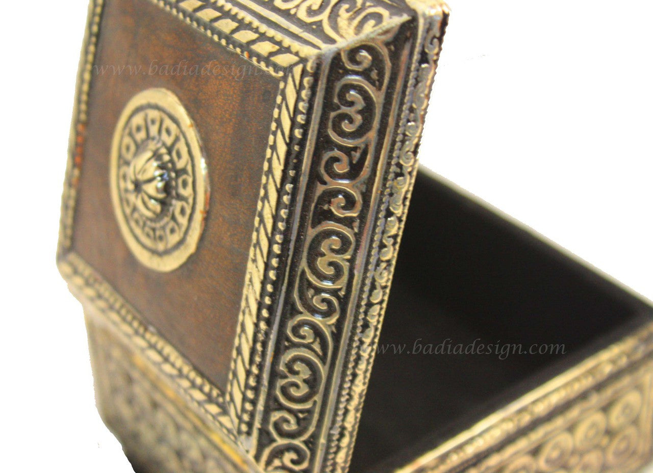Decorative jewelry box with intricate patterns and a central emblem on a white background