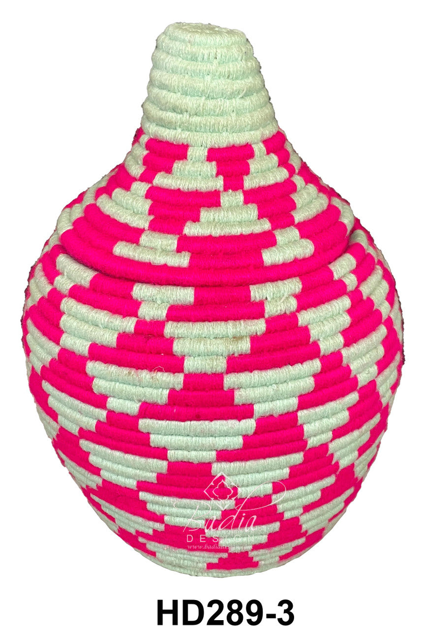 Pink and white woven berber basket on a white background