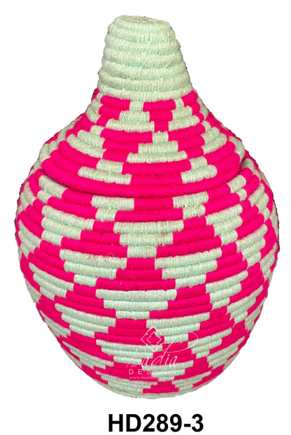 Pink and white woven berber basket on a white background
