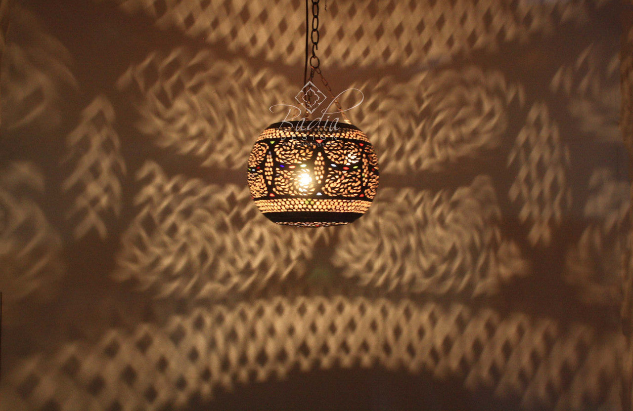 Decorative hanging light fixture casting shadows on a textured wall.