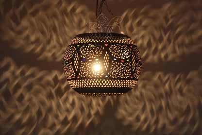 Decorative hanging lamp casting shadows on a textured wall