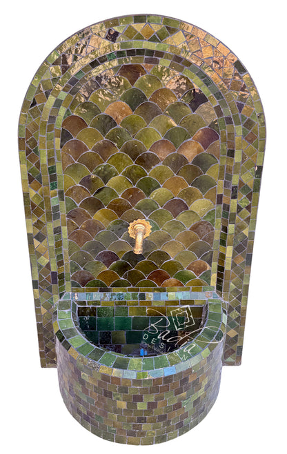 A mosaic tile fountain with an arched back panel and a curved basin, featuring green, brown, and gold iridescent tiles with a central gold spout.