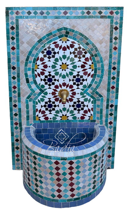A Moorish-style mosaic fountain wall and basin with intricate geometric tile patterns in turquoise, blue, white, green, and burgundy, featuring a central brass  spout.