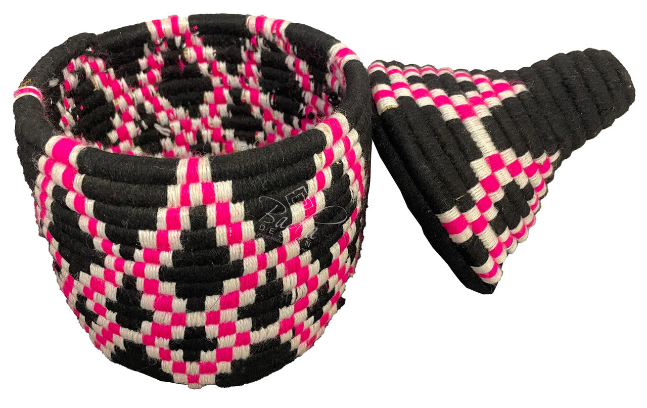 Woven berber basket in pink, black, and white pattern on a white background