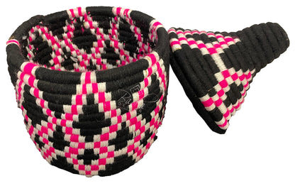 Woven berber basket in pink, black, and white pattern on a white background