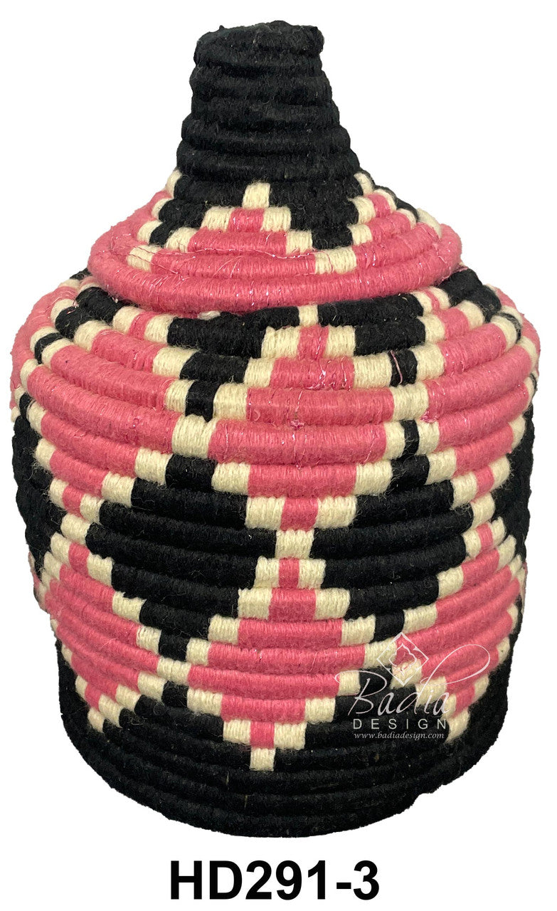 Decorative woven container with pink, black, and beige pattern on a white background