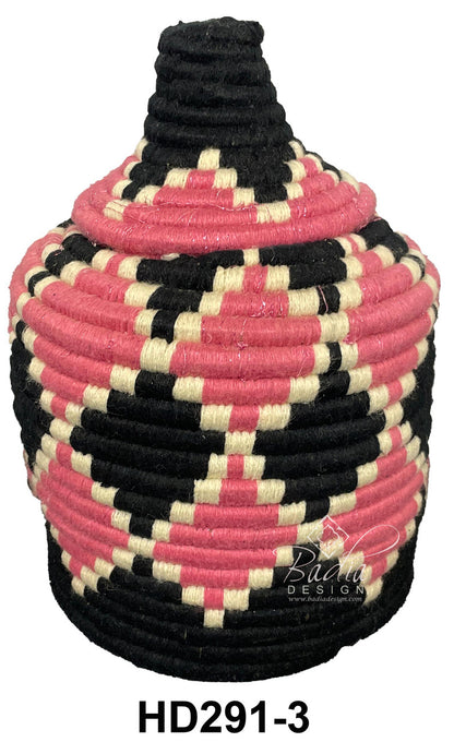 Decorative woven container with pink, black, and beige pattern on a white background