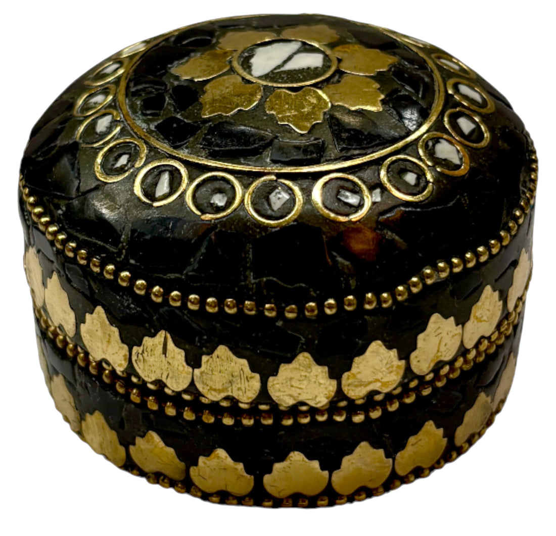 Decorative black and gold box with intricate patterns on a white background