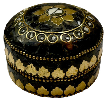 Decorative black and gold box with intricate patterns on a white background