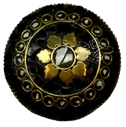Decorative button with gold and black design  top on a white background