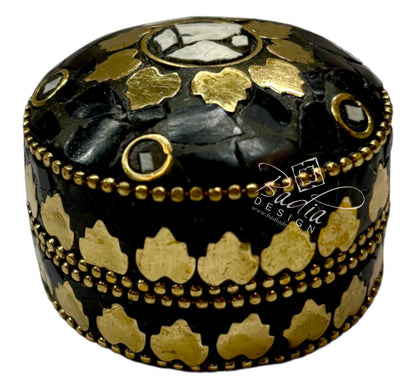 Decorative black and gold box with intricate patterns on a white background