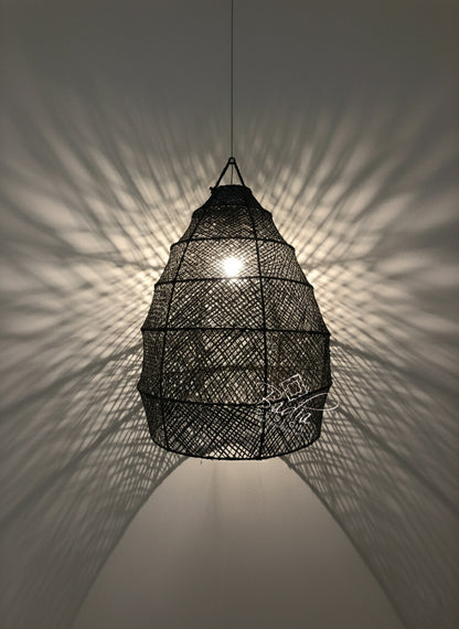 Black woven pendant light casting shadows on a wall