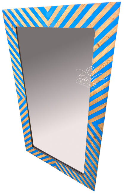 A rectangular wall mirror with a decorative frame featuring alternating diagonal stripes of bright blue and natural wood grain.