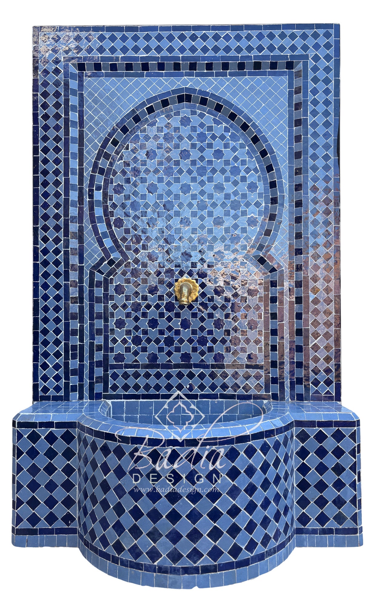 A Moorish-style mosaic tile fountain wall and basin in shades of blue, with a central gold-tone spout and a decorative script watermark reading &