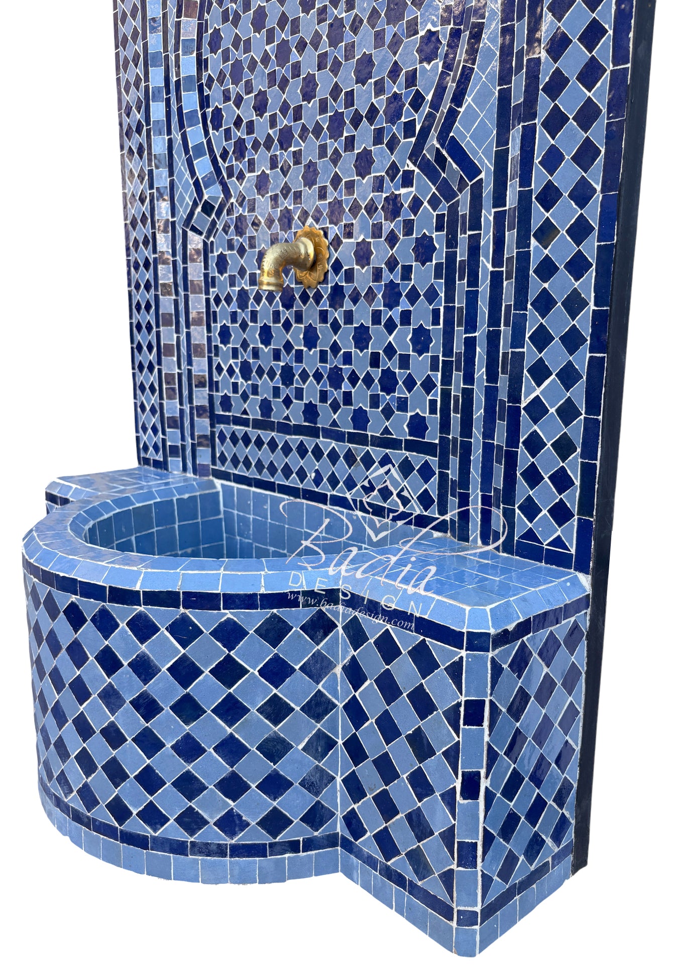 A Moroccan-style mosaic tile fountain with a curved basin and a tall patterned wall, decorated in shades of blue with a small brass spout.