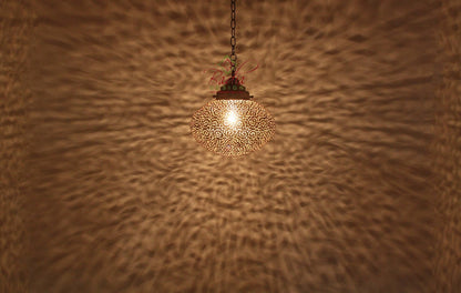 Decorative ceiling light fixture casting a warm glow on a textured wall.