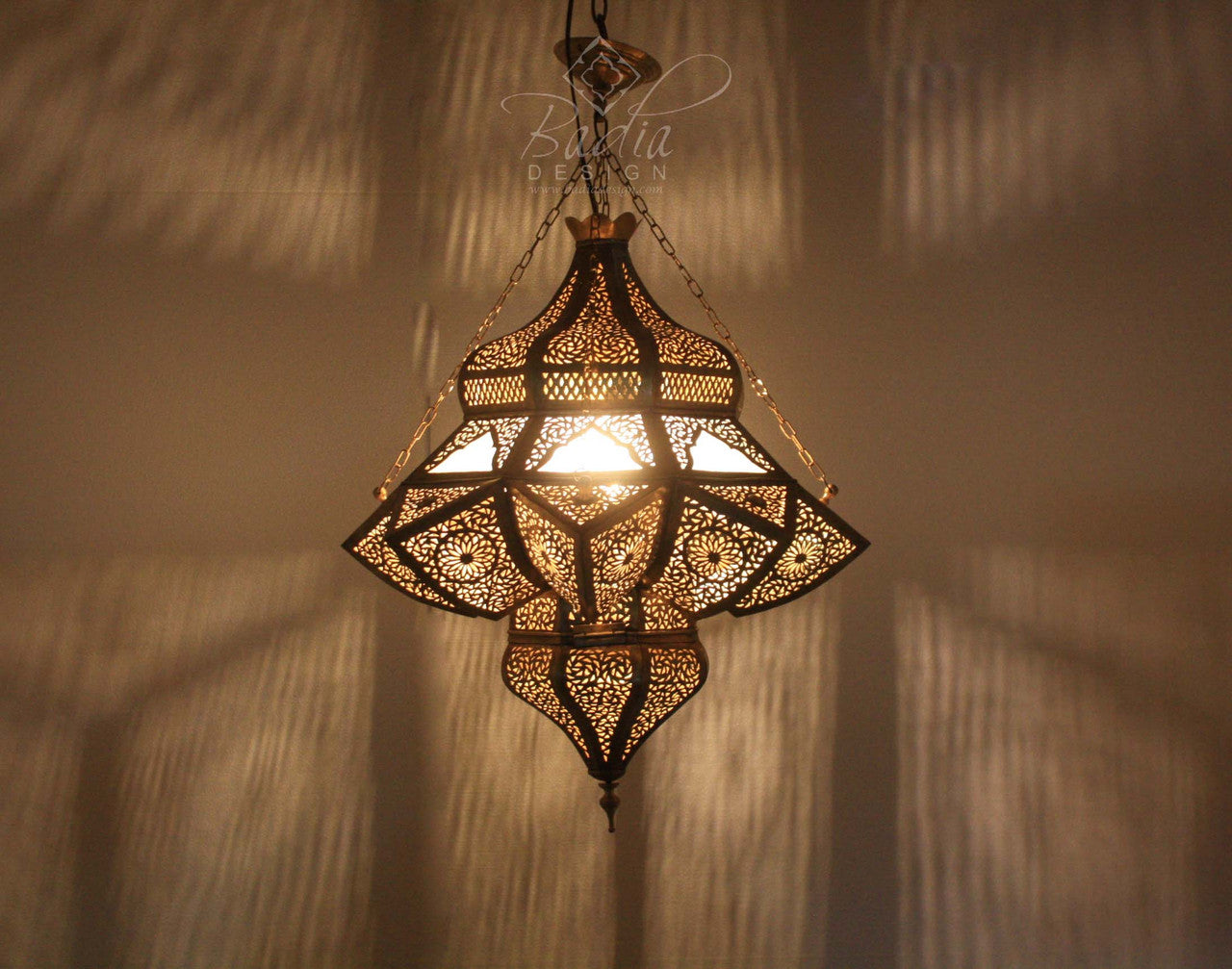 Decorative hanging lamp with intricate patterns on a textured wall background