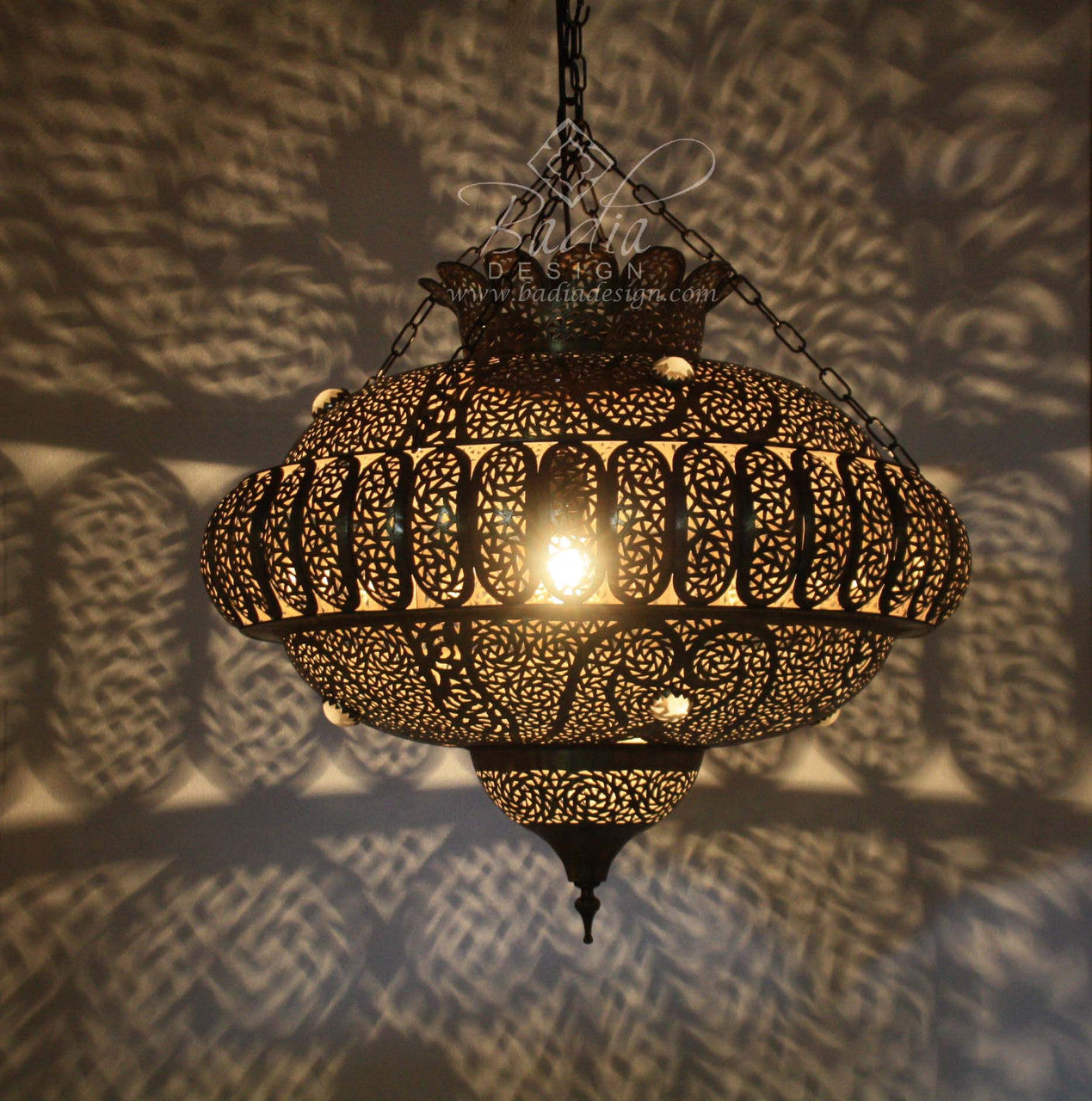 Decorative hanging lamp casting shadows on a textured wall