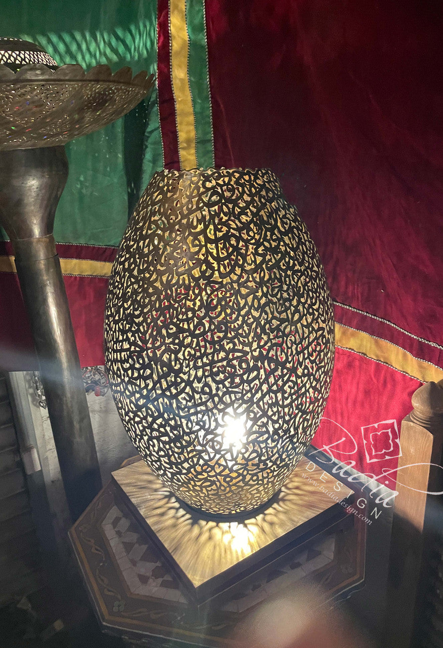 Decorative lamp with intricate design on a colorful fabric background
