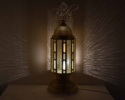 Decorative lamp with intricate design on a dark background, featuring the Badia Design logo.