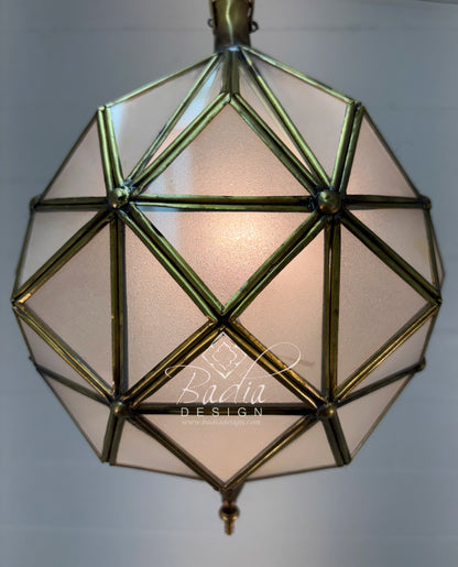 Geometric pendant light with brass frame and soft white glass on a neutral background
